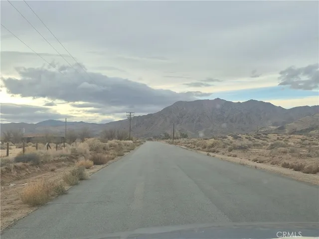 a view of a dry yard and mountains