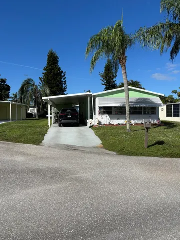 a view of a house with a yard and sitting area