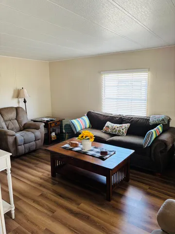 a living room with furniture and wooden floor