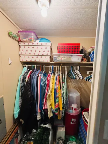 a view of walk in closet with clothes
