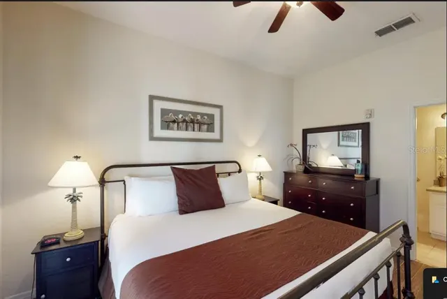 a bedroom with a bed and a lamp on dresser