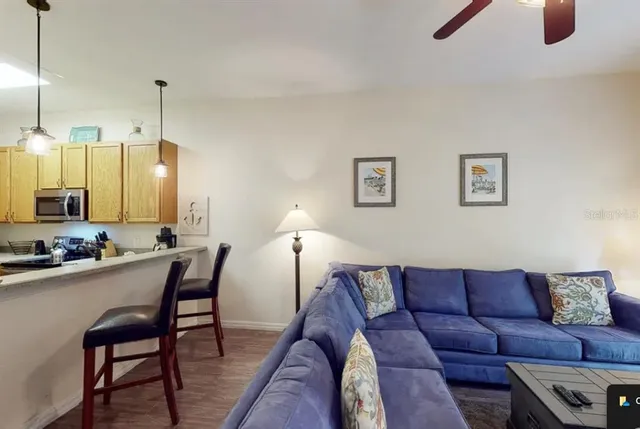 a living room with furniture a flat screen tv and kitchen view
