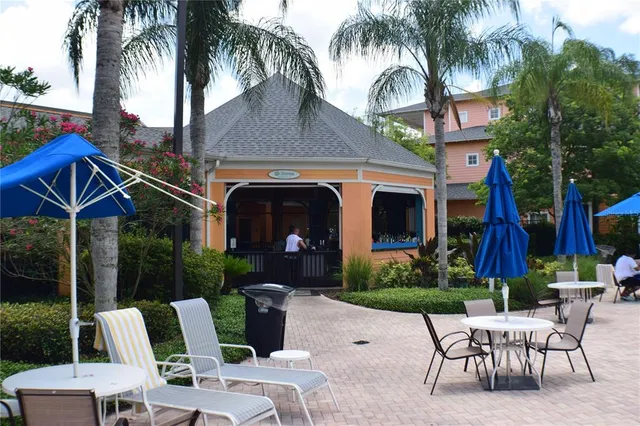 a view of a patio with table and chairs potted plants and palm tree