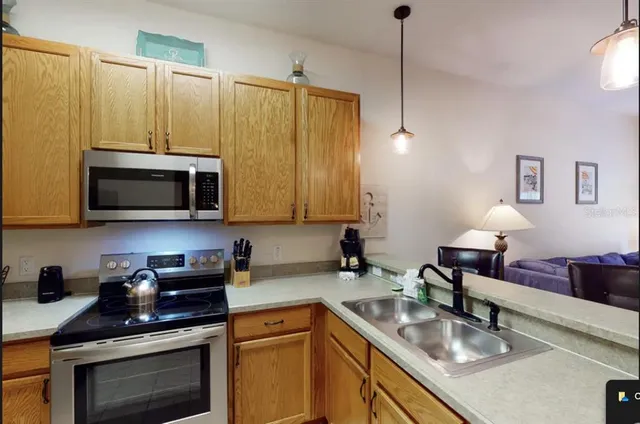 a kitchen with stainless steel appliances granite countertop a sink a stove and a microwave