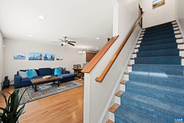 a view of a hallway with wooden floor and staircase