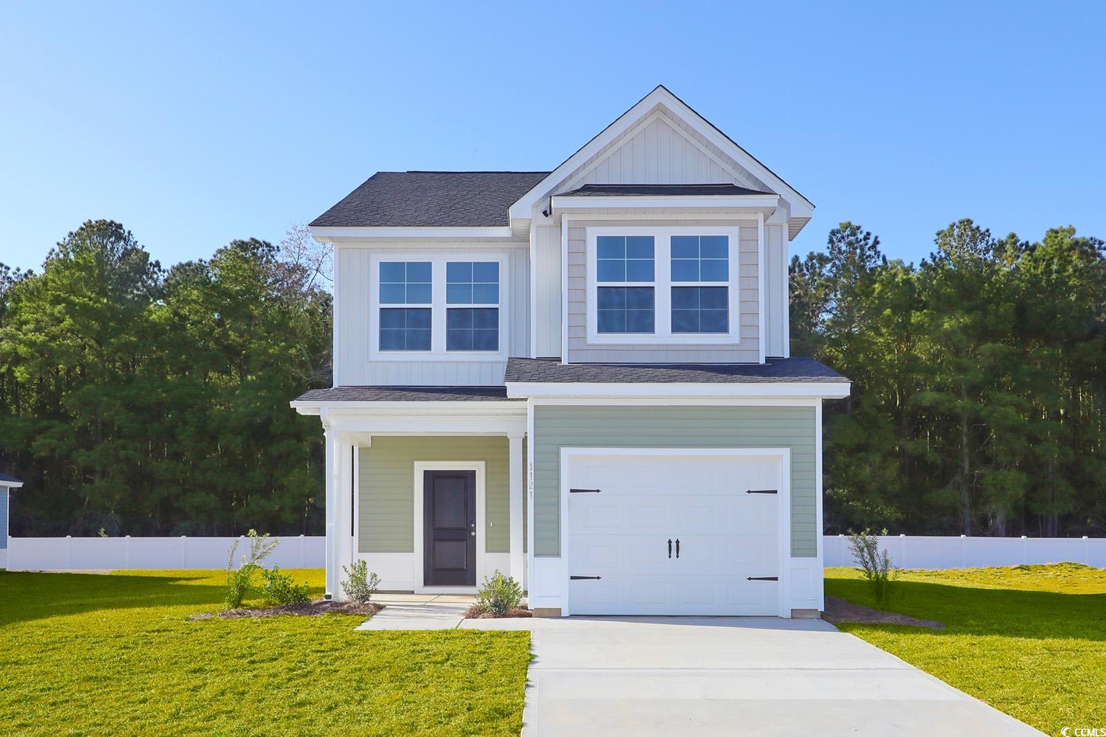 View of front of home with board and batten siding, roof with shingles, an attached garage, and driveway