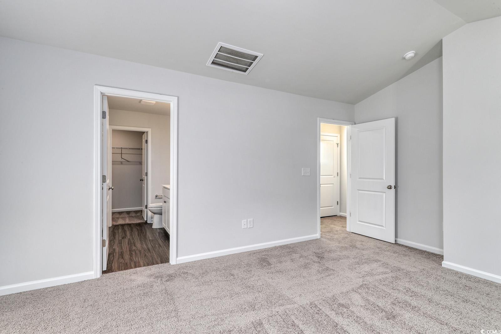 1121 Hainer Place Drive Conway, SC 29526 - Photo 13 of 28 Unfurnished bedroom with dark colored carpet, lofted ceiling, and ensuite bath