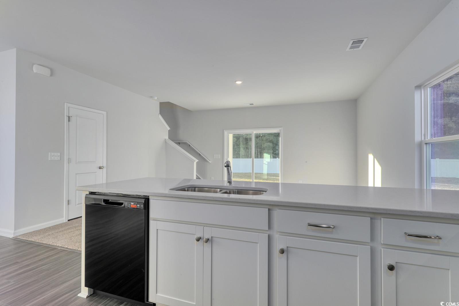 1121 Hainer Place Drive Conway, SC 29526 - Photo 5 of 28 Kitchen featuring white cabinets, black dishwasher, light stone countertops, and light wood-style floors