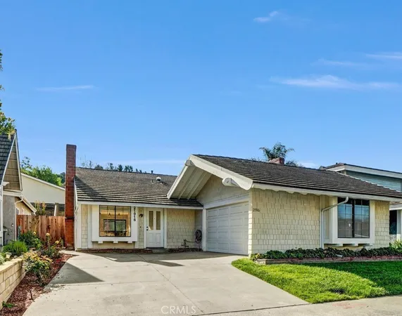 a front view of a house with a yard and potted plants
