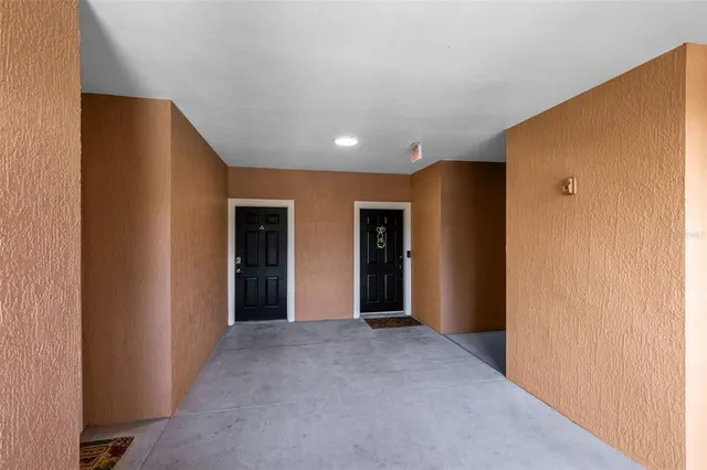 front view of a brick house with a yard and large trees