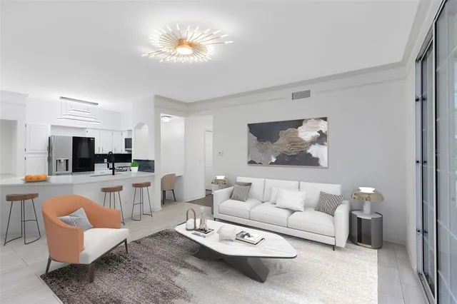 a living room with furniture kitchen view and a chandelier