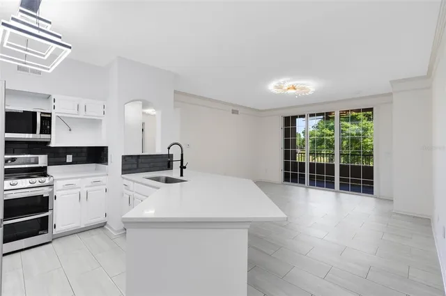 a kitchen with a sink a stove and cabinets