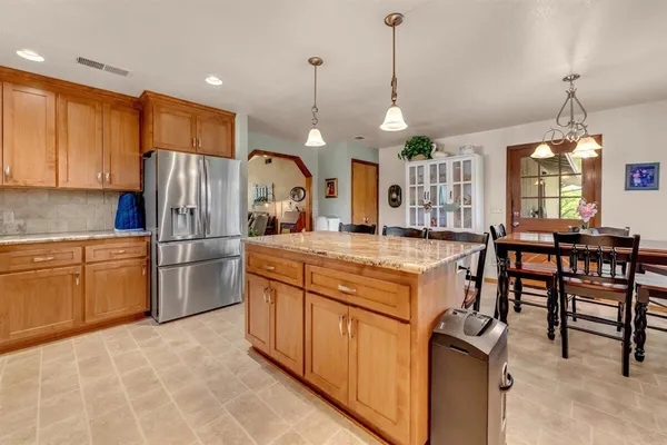 a kitchen with refrigerator a table and chairs