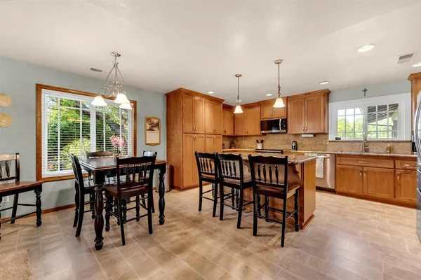 a kitchen with kitchen island a dining table and chairs
