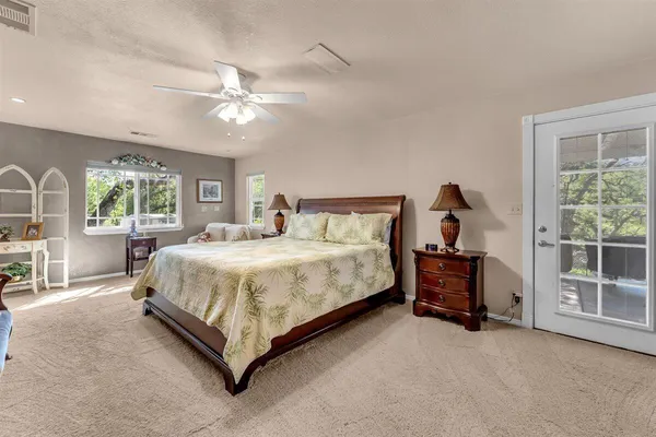 a spacious bedroom with a bed and a chandelier