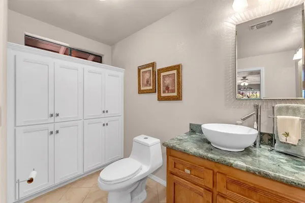 a bathroom with a granite countertop toilet and a sink