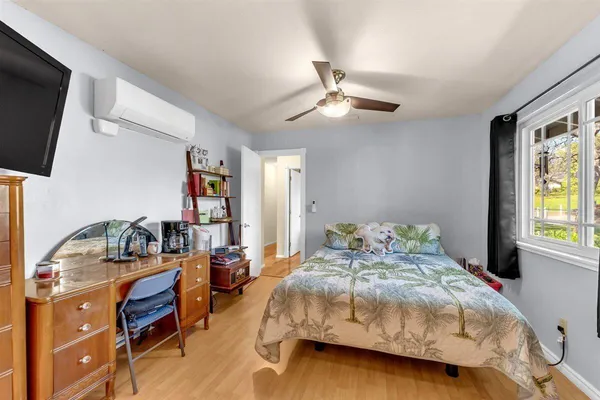 a bedroom with a bed and a flat tv screen on the dresser