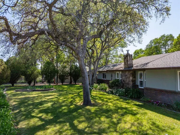 a view of a house with backyard and trees