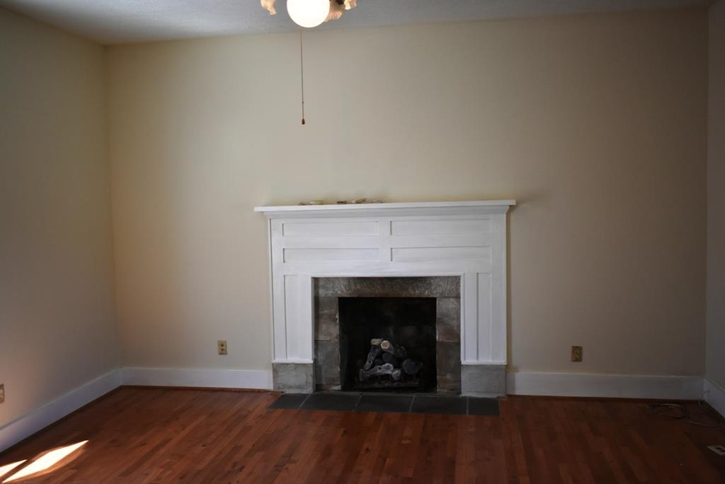 14436 Indian Springs Road Buffalo Valley, TN 38548 - Photo 2 of 24 a view of an empty room with wooden floor and a fireplace