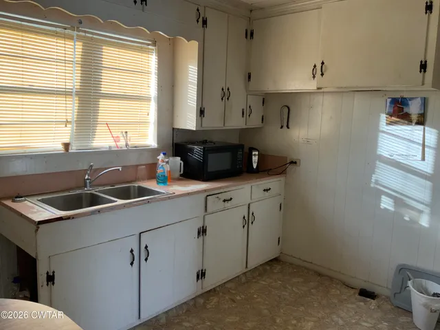 a kitchen with stainless steel appliances granite countertop a sink stove and white cabinets