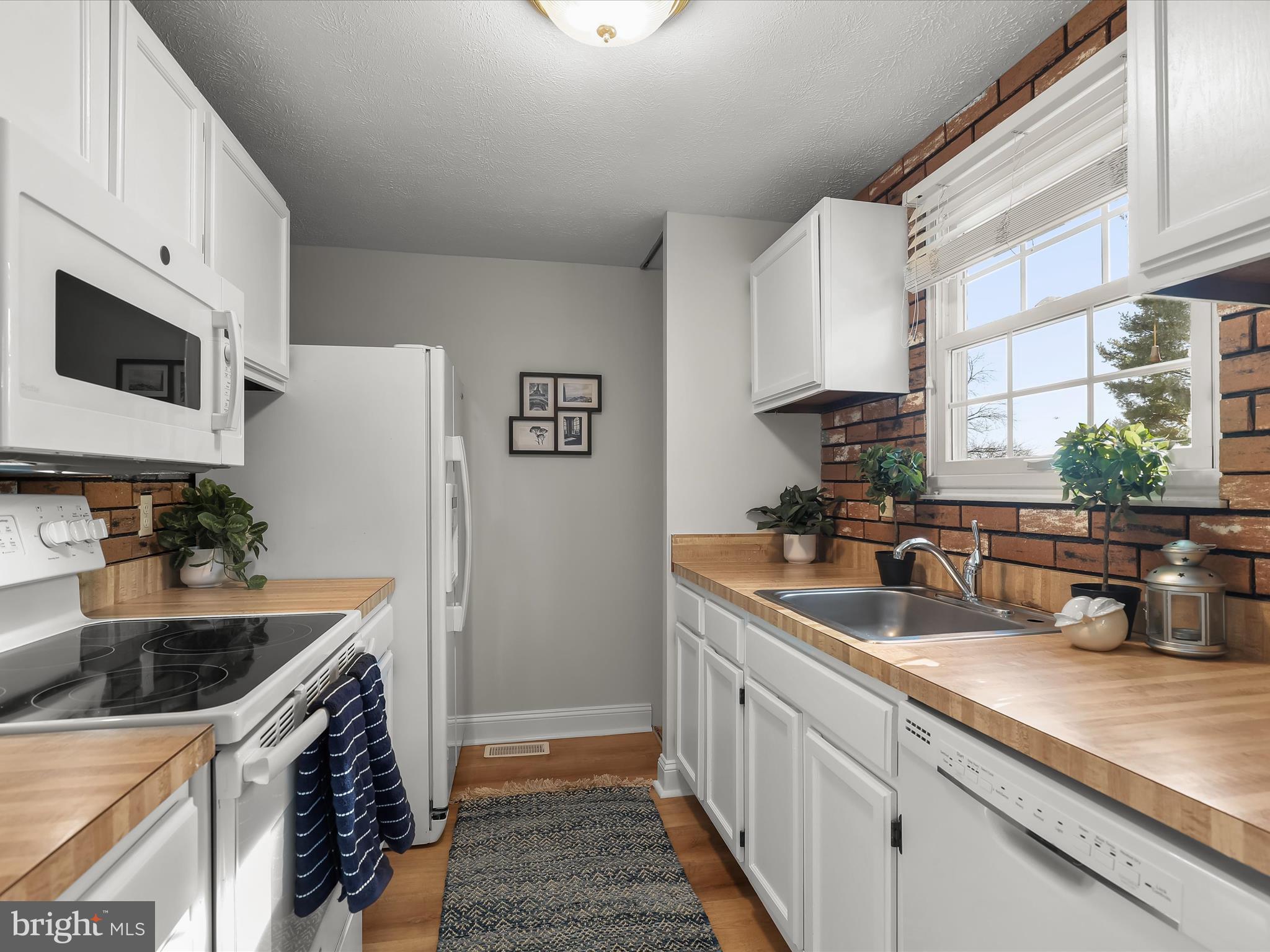 7971 Quail Court Glen Burnie, MD 21061 - Photo 14 of 52 a kitchen with stainless steel appliances granite countertop a sink a stove and a refrigerator with wooden cabinets