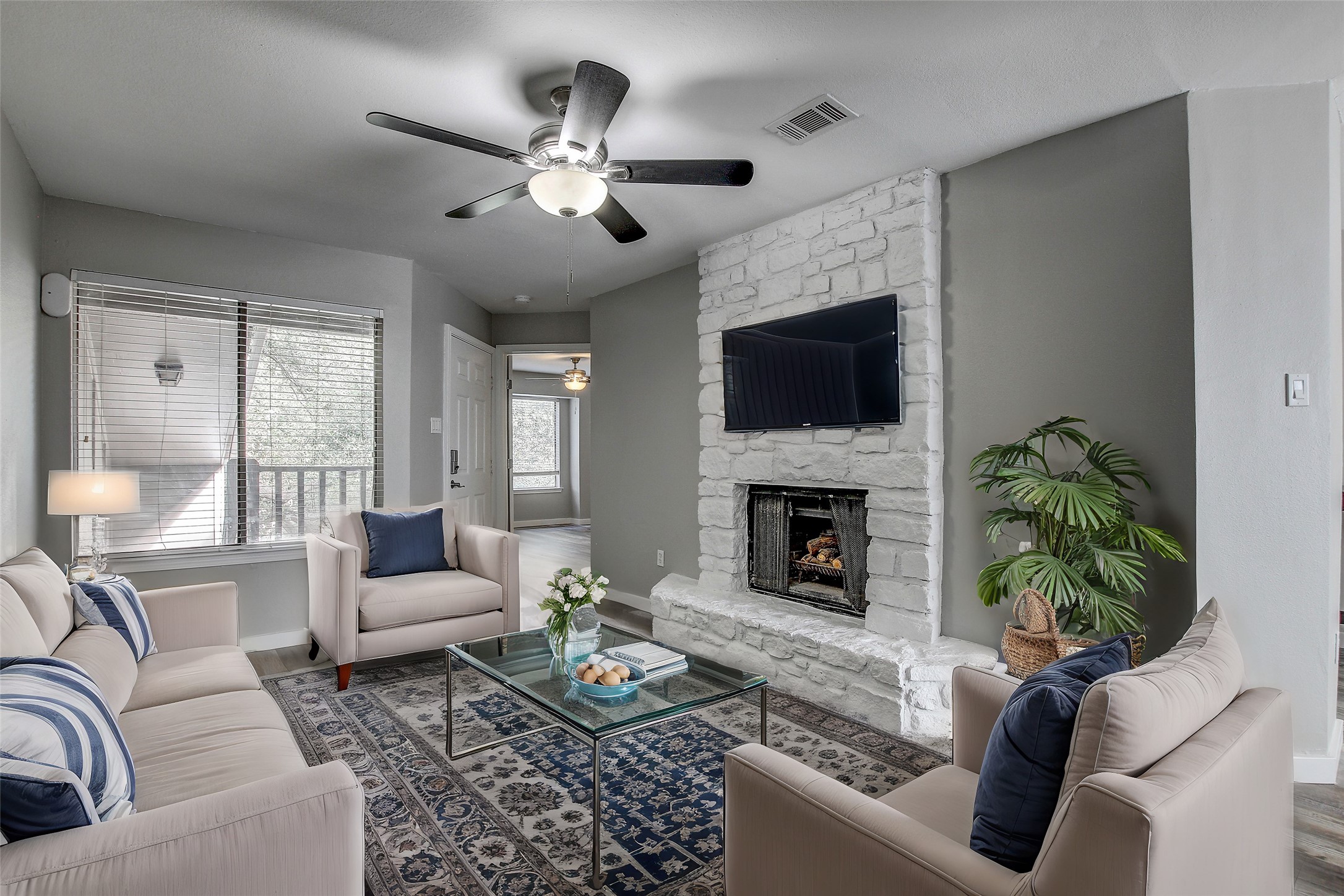 1740 Timber Ridge Road, Unit 136 Austin, TX 78741 - Photo 1 of 1 a living room with furniture a fireplace and a flat screen tv