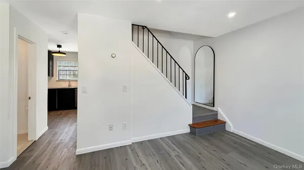 a view of an entryway with wooden floor and staircase