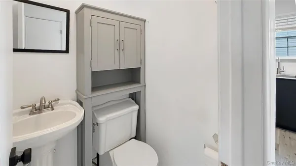 a bathroom with a toilet sink and mirror
