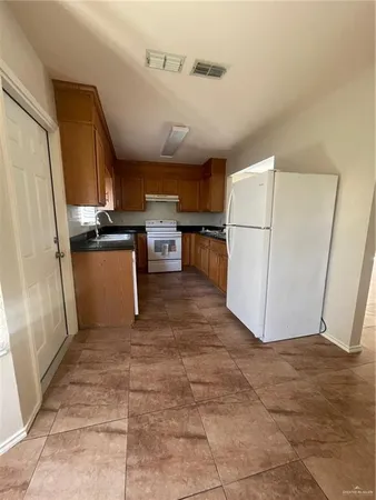 a view of kitchen with window and refrigerator