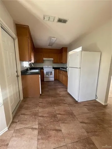 a view of kitchen with window and refrigerator