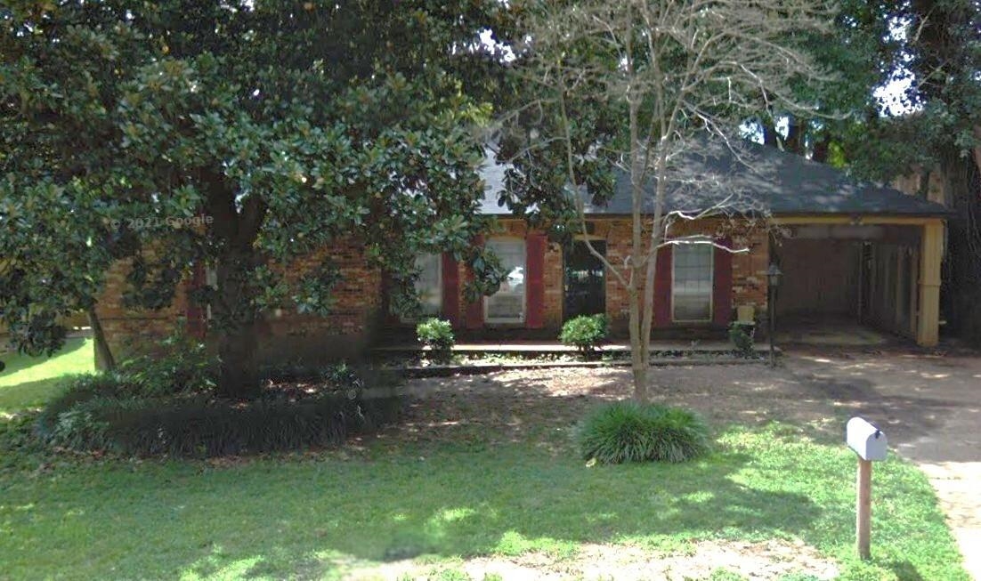 a backyard of a house with table and chairs