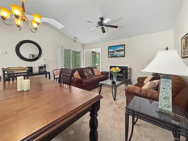 a living room with furniture a chandelier fan and a window