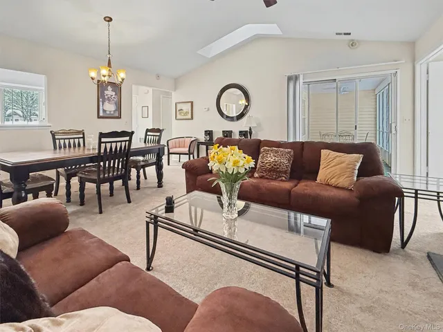 a living room with furniture a chandelier and a dining table