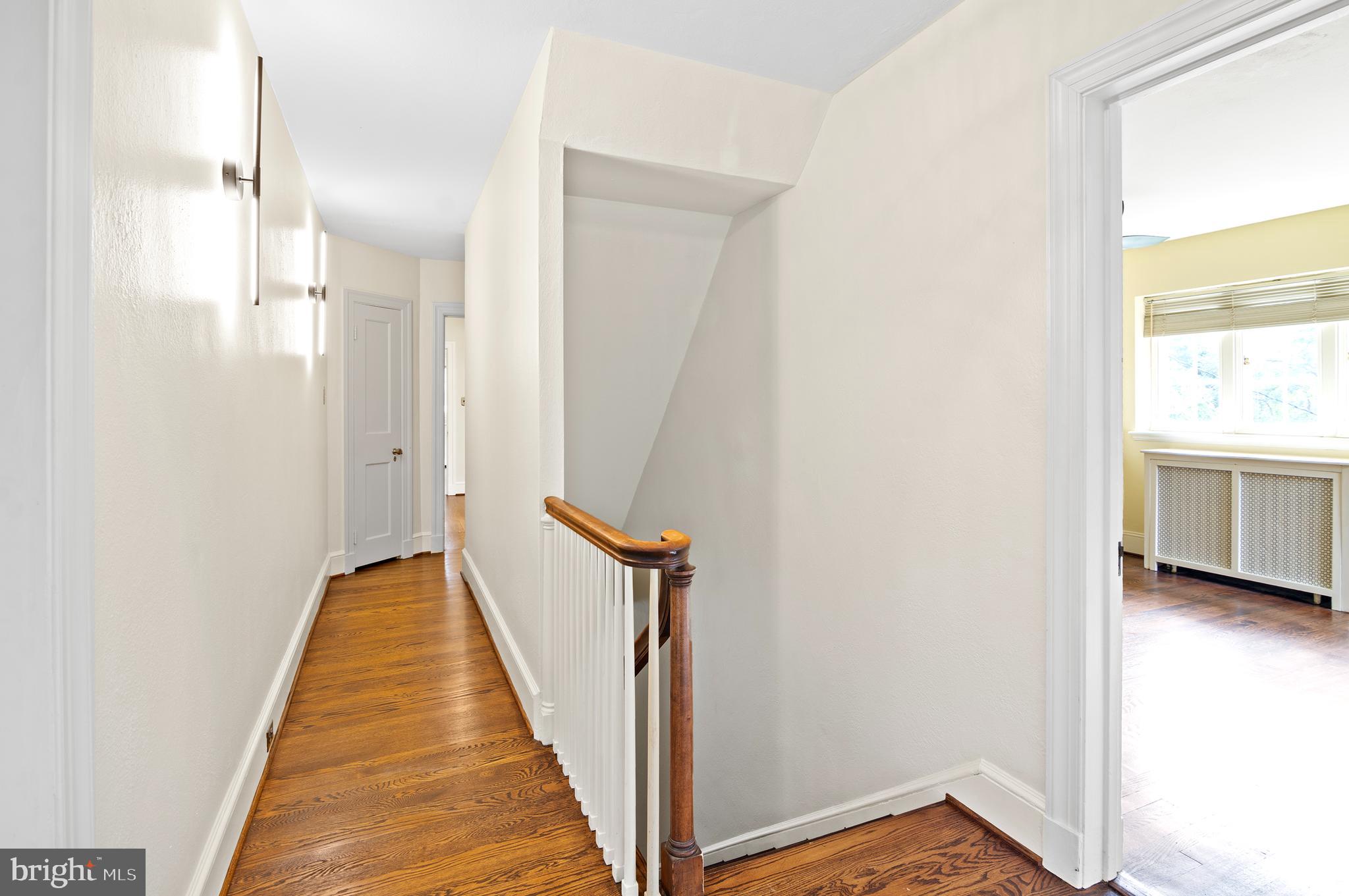 7704 Crossland Road Pikesville, MD 21208 - Photo 25 of 68 a view of a hallway with wooden floor and a bathroom