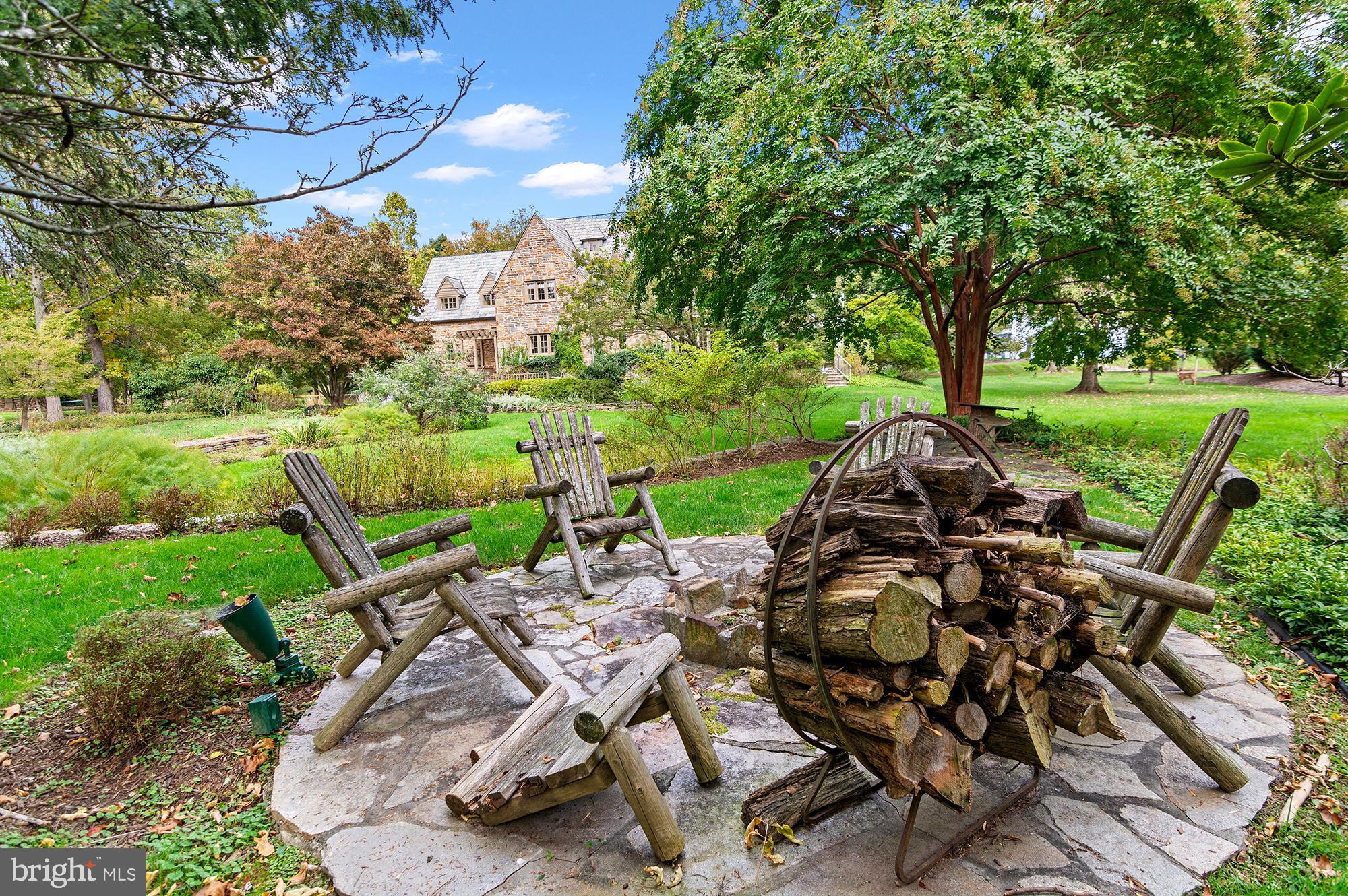 7704 Crossland Road Pikesville, MD 21208 - Photo 61 of 68 a view of a backyard with table and chairs potted plants and large tree