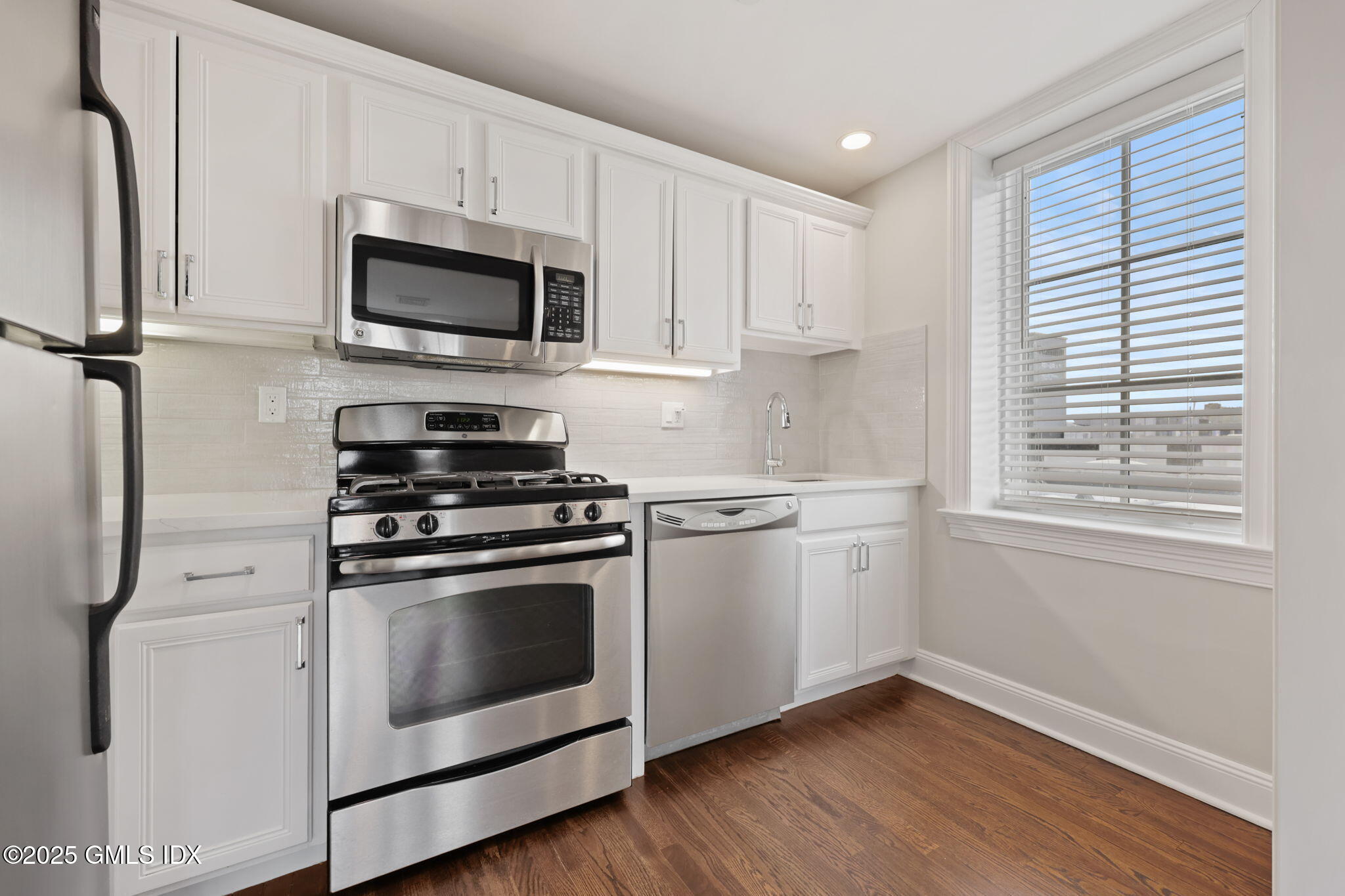 2 East Elm Street, Unit 35 Greenwich, CT 06830 - Photo 6 of 26 a kitchen with stainless steel appliances white cabinets and a stove top oven