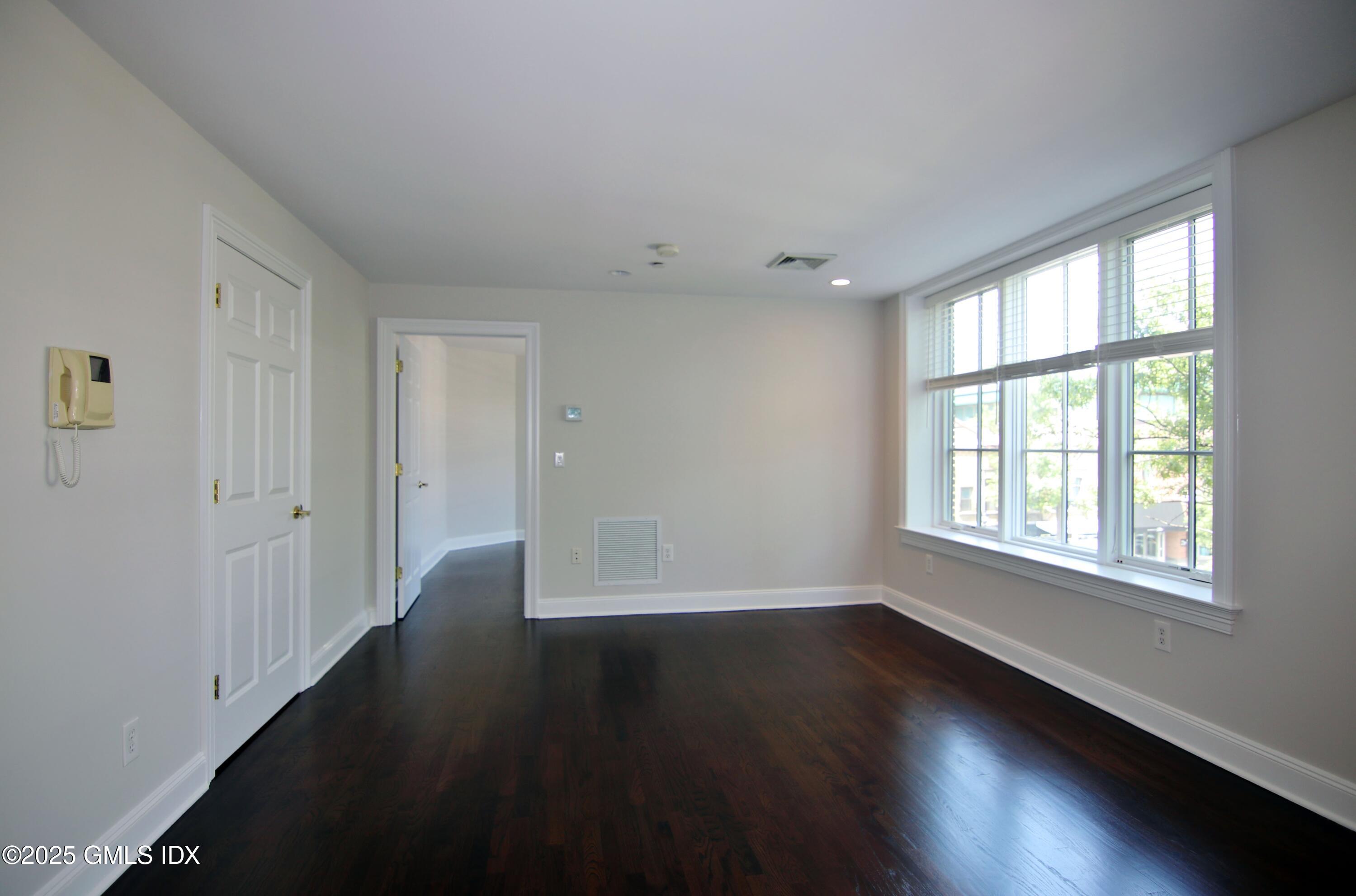 2 East Elm Street, Unit 35 Greenwich, CT 06830 - Photo 8 of 21 a view of an empty room with wooden floor and a window
