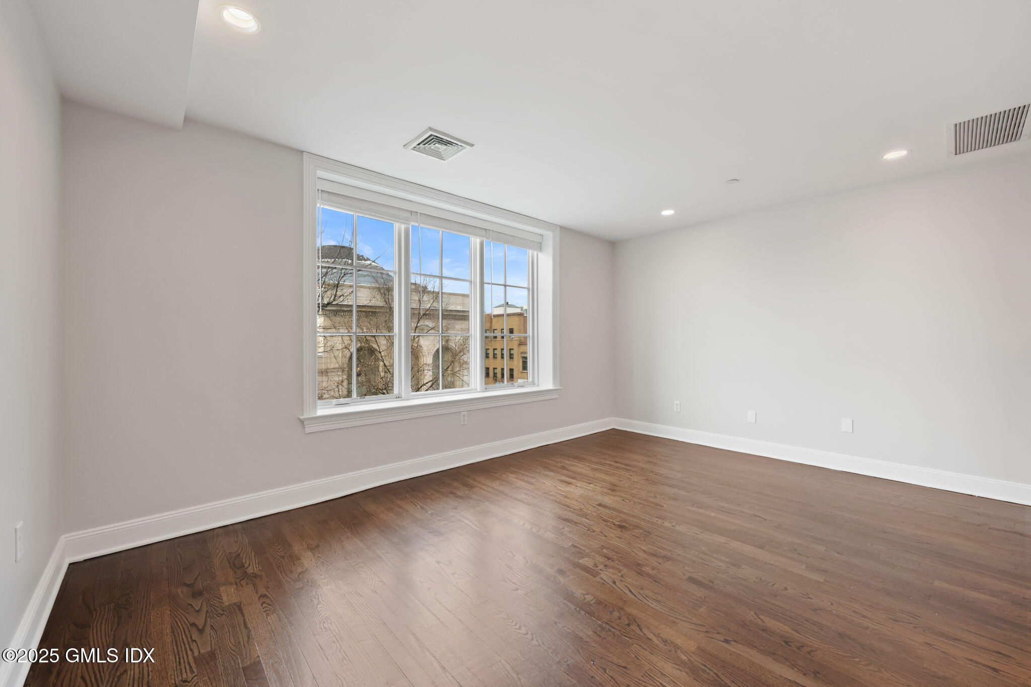 2 East Elm Street, Unit 35 Greenwich, CT 06830 - Photo 9 of 26 an empty room with wooden floor and windows