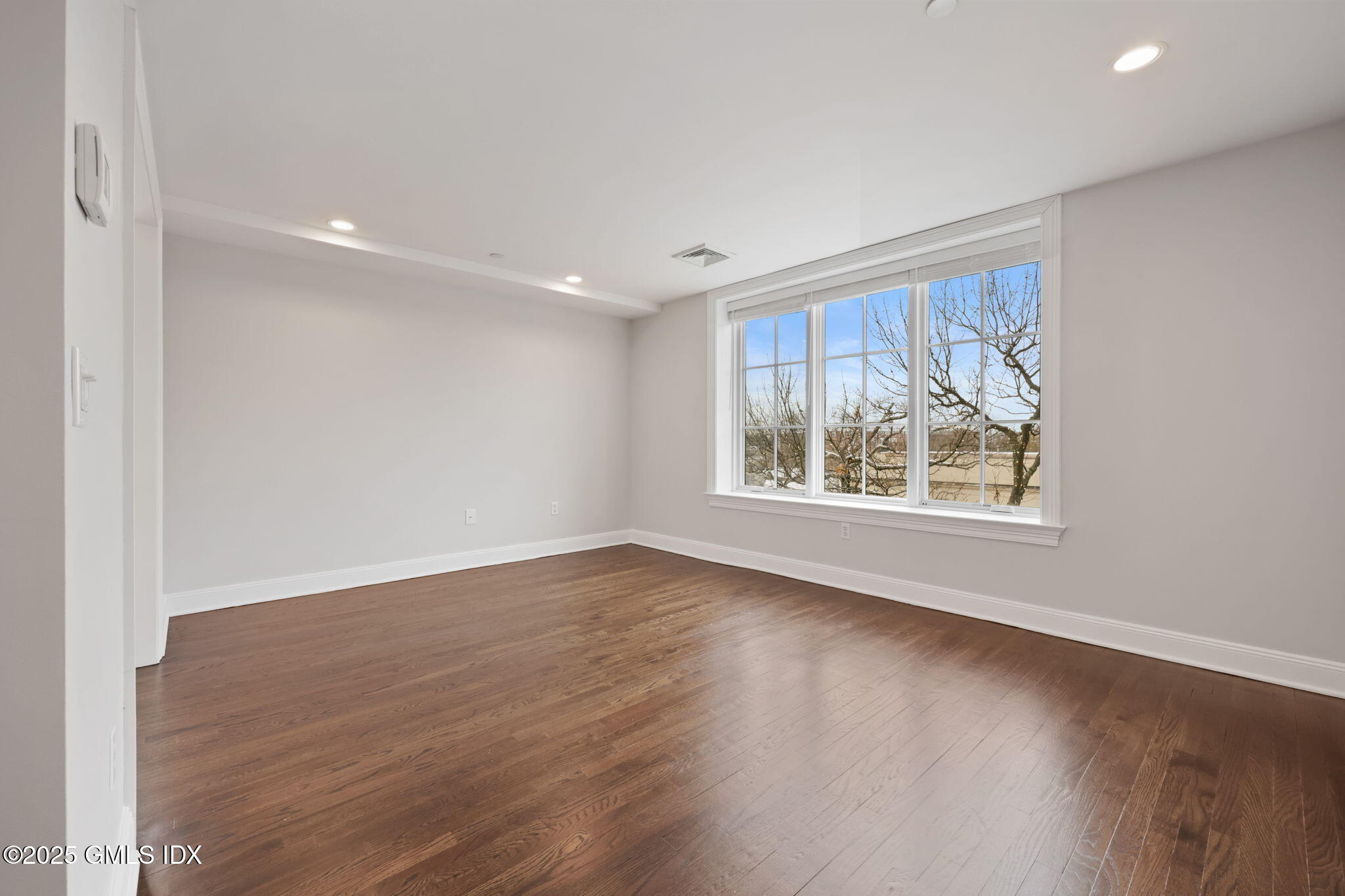2 East Elm Street, Unit 35 Greenwich, CT 06830 - Photo 10 of 26 an empty room with wooden floor and windows