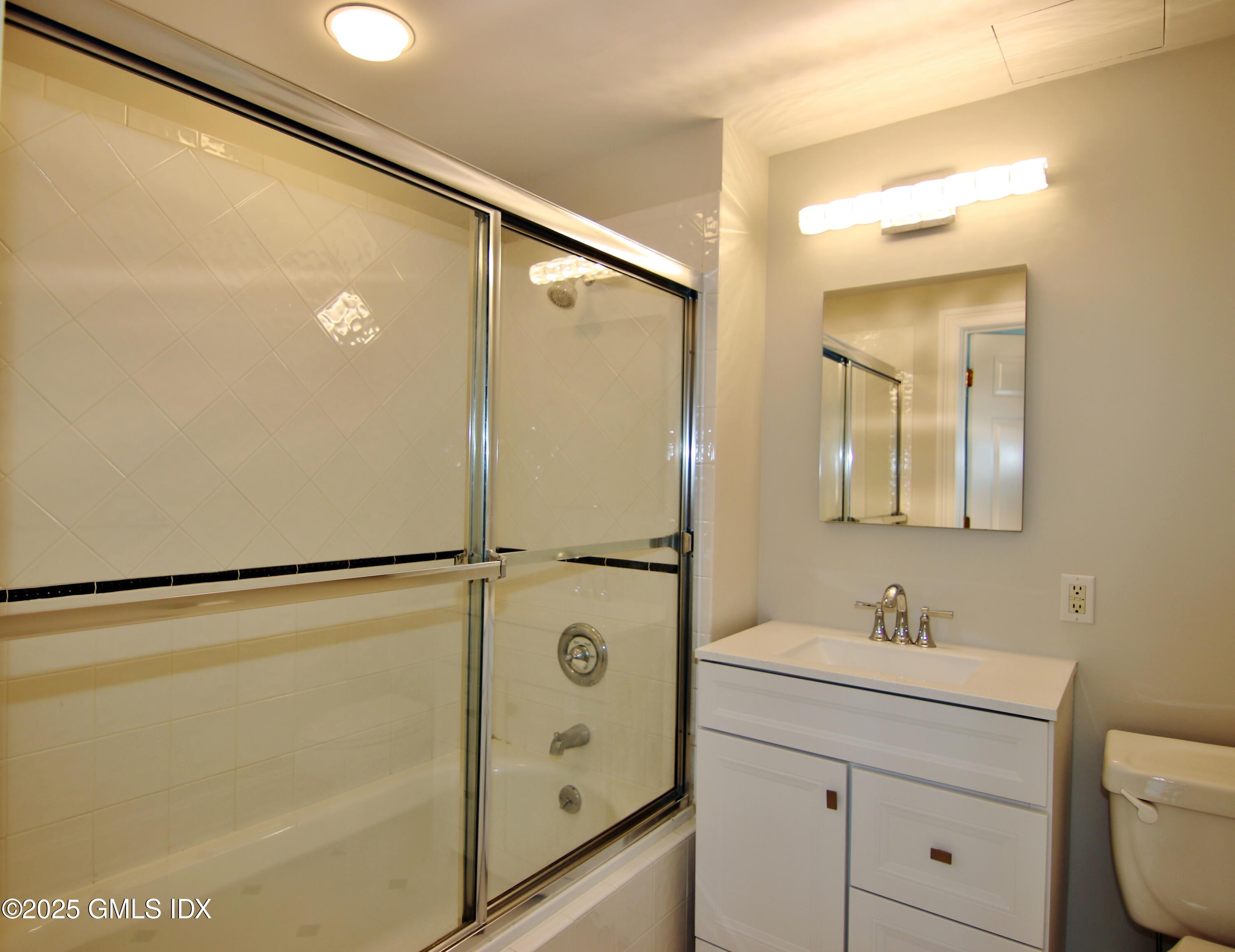 2 East Elm Street, Unit 35 Greenwich, CT 06830 - Photo 10 of 21 a bathroom with a shower sink and mirror