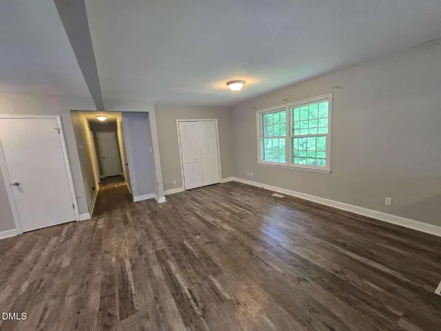 an empty room with wooden floor and a window