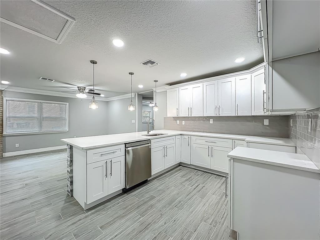 1414 Beaver Street Orlando, FL 32806 - Photo 12 of 43 a large white kitchen with wooden floors and white cabinets
