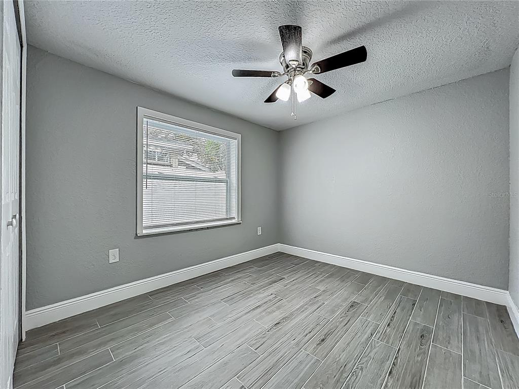 1414 Beaver Street Orlando, FL 32806 - Photo 18 of 43 a view of an empty room with wooden floor and a window