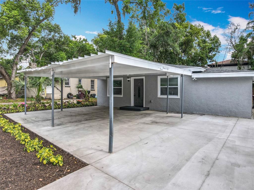 1414 Beaver Street Orlando, FL 32806 - Photo 3 of 43 a view of a white house with large windows and plants