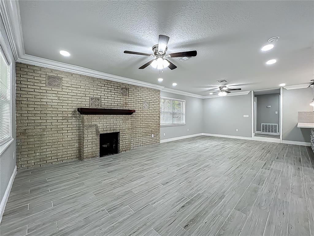 1414 Beaver Street Orlando, FL 32806 - Photo 6 of 43 a view of an empty room with wooden floor and a fireplace