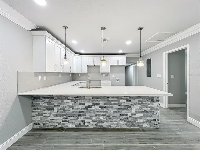a kitchen with granite countertop a stove a sink and a refrigerator