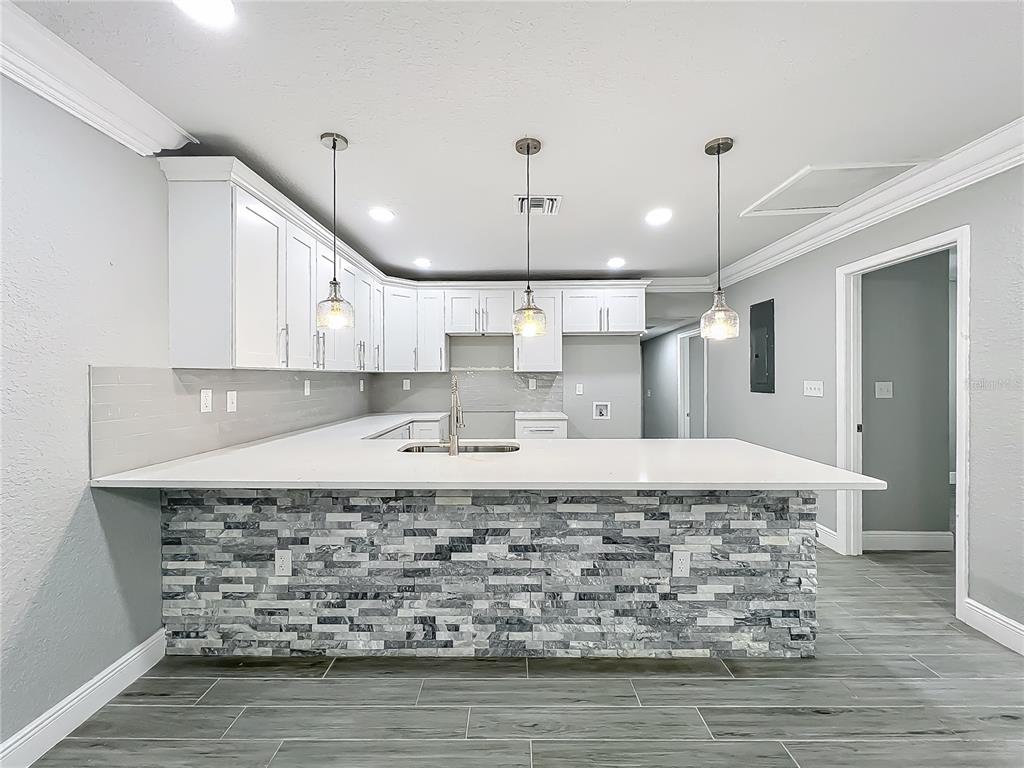 1414 Beaver Street Orlando, FL 32806 - Photo 9 of 43 a large kitchen with kitchen island a sink stainless steel appliances and cabinets
