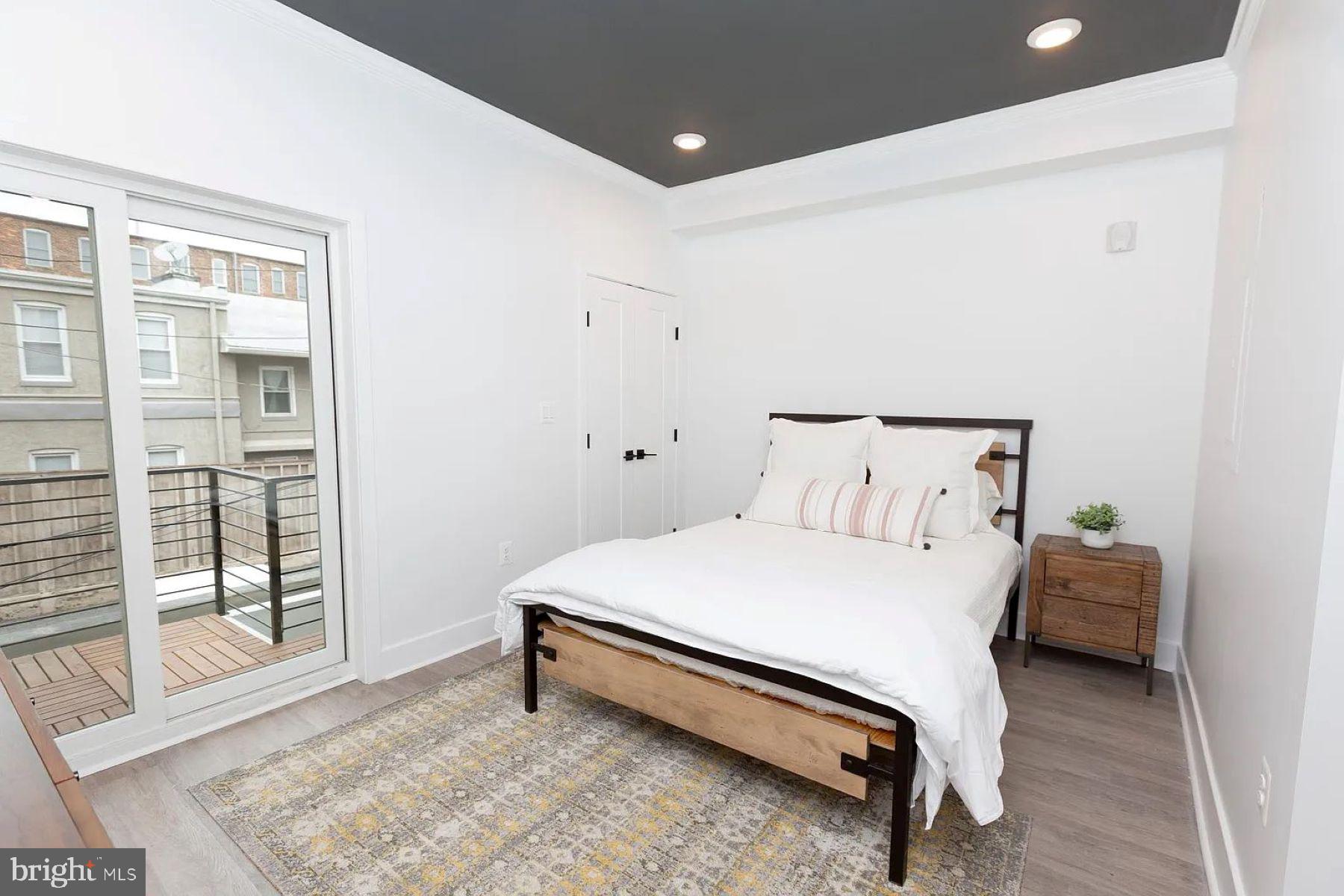 1742 Fleet Street, Unit 301 Baltimore, MD 21231 - Photo 7 of 20 a spacious bedroom with a bed and wooden floor