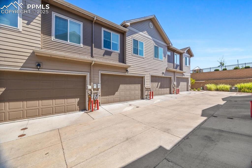 15446 West 64th Loop, Unit D Arvada, CO 80007 - Photo 17 of 22 a front view of a house with a yard and garage