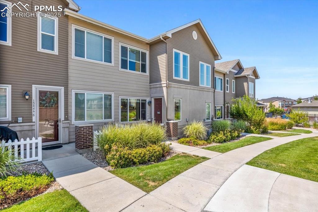15446 West 64th Loop, Unit D Arvada, CO 80007 - Photo 2 of 22 a front view of house and yard with green space